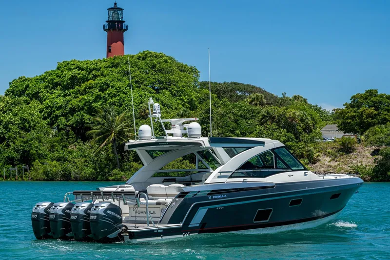  Yacht Photos Pics 2019 Formula 430 Super Sport Crossover yacht cruising near a lighthouse and lush greenery.