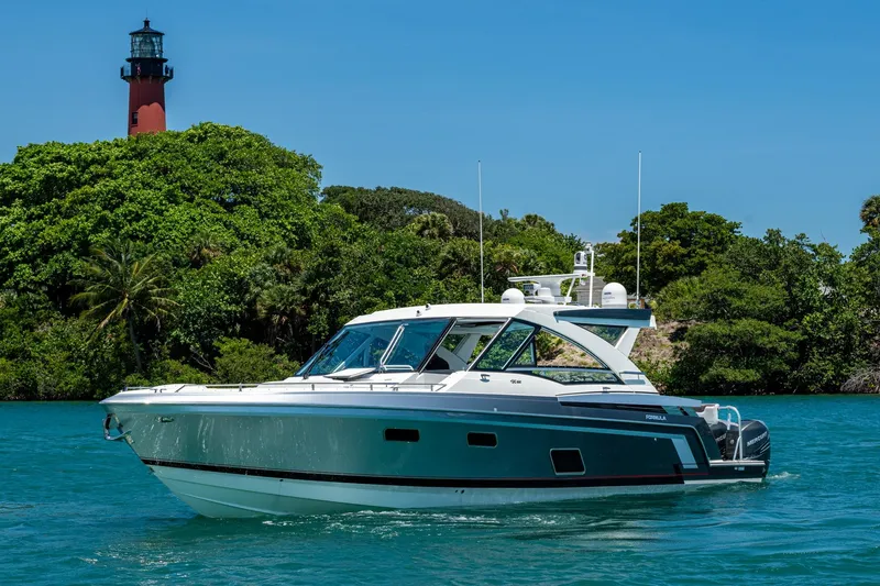  Yacht Photos Pics 2019 Formula 430 Super Sport Crossover yacht near lush greenery and lighthouse.