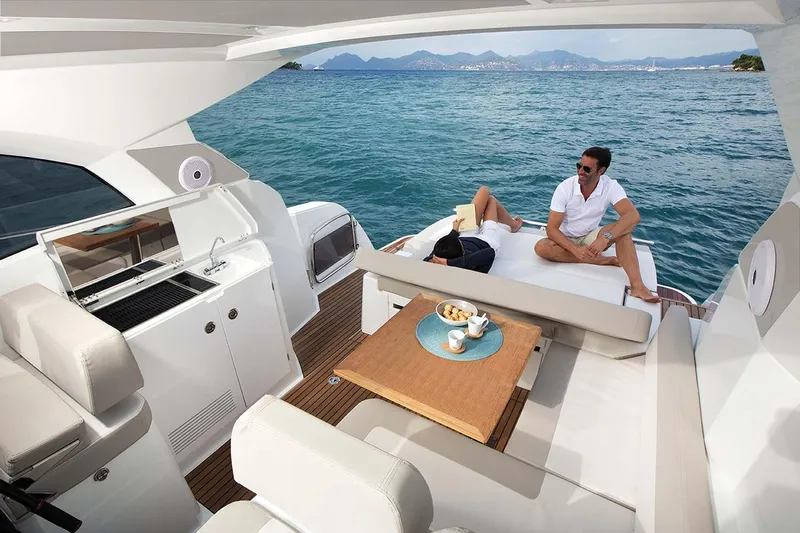 Lololand Yacht Photos Pics Manufacturer Provided Image: 2018 Jeanneau Leader 36 yacht with people relaxing on deck, ocean view.