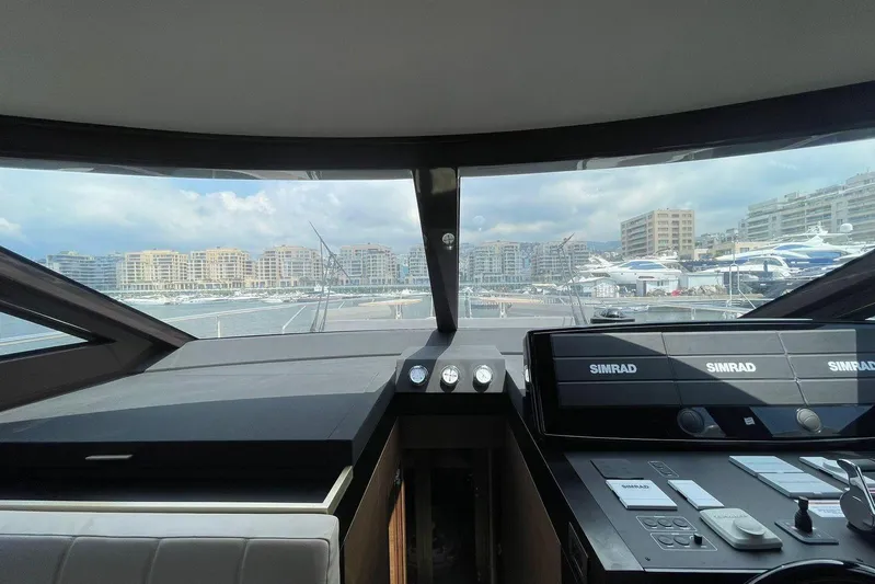  Yacht Photos Pics Cockpit view of 2021 Ferretti Yachts 670, featuring modern navigation systems and marina backdrop.