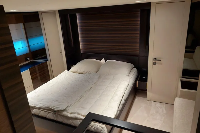  Yacht Photos Pics Luxurious bedroom interior of 2021 Ferretti Yachts 670, featuring modern design and cozy bedding.