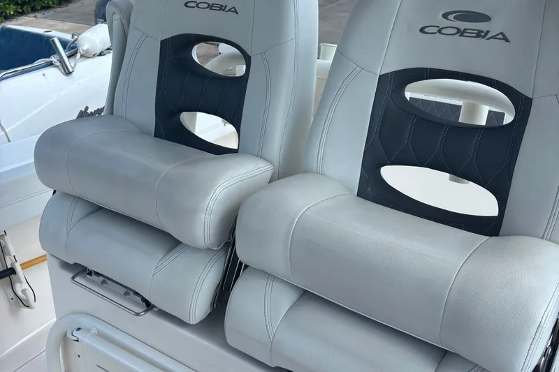  Yacht Photos Pics 2022 Cobia 280 Center Console boat seats with logo, featuring plush gray upholstery.