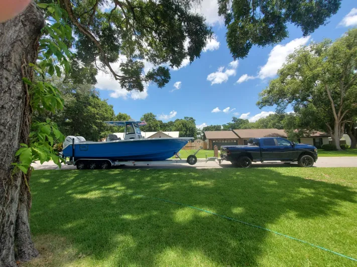  Yacht Photos Pics 2024 Sea Hunt Ultra 305 SE boat on trailer, towed by a truck in a suburban neighborhood.