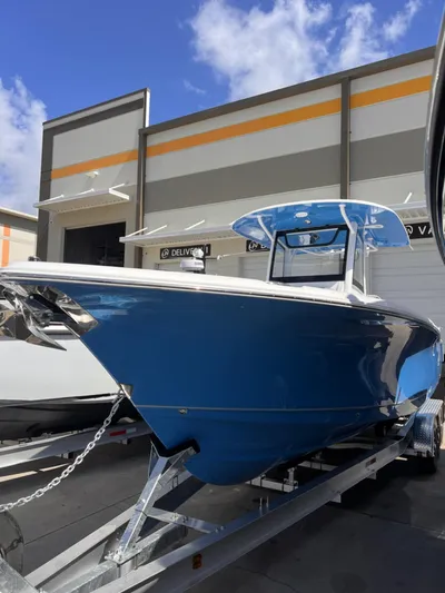  Yacht Photos Pics 2024 Sea Hunt Ultra 305 SE boat in blue, displayed on a trailer outside a building.