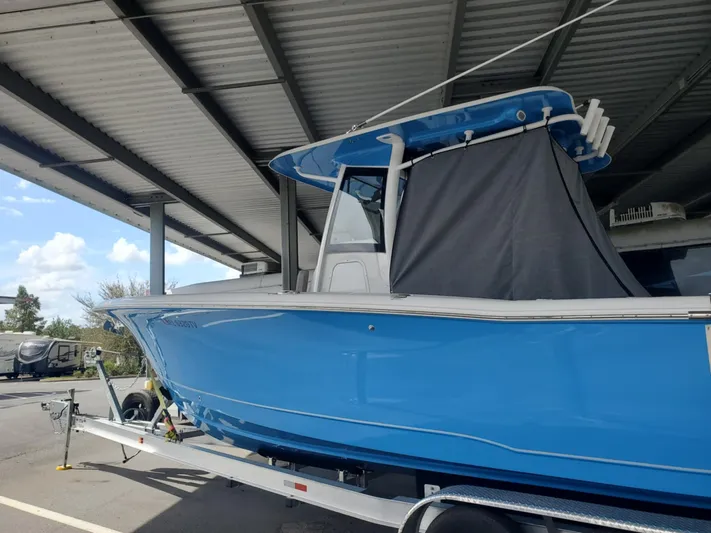  Yacht Photos Pics 2024 Sea Hunt Ultra 305 SE boat in blue, parked under a metal canopy.