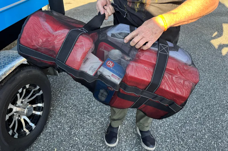  Yacht Photos Pics Man holding a mesh bag with supplies near a Sea Hunt Ultra 305 SE boat.