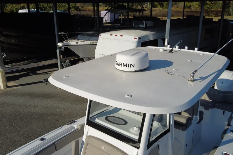  Yacht Photos Pics 2024 Sea Hunt Ultra 305 SE boat with Garmin radar, docked in a covered marina.