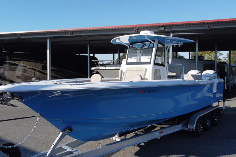 Yacht Photos Pics 2024 Sea Hunt Ultra 305 SE boat on trailer, blue hull, parked in marina.