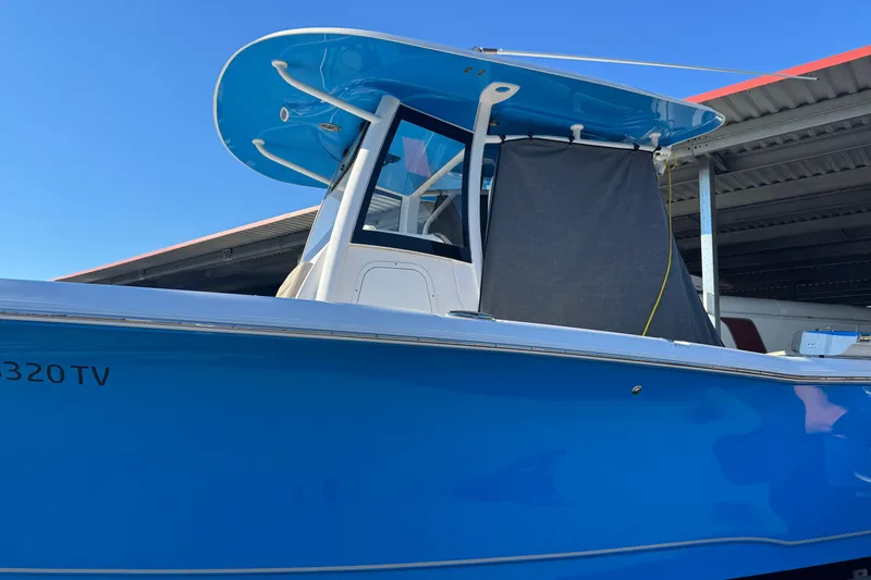  Yacht Photos Pics 2024 Sea Hunt Ultra 305 SE boat with blue hull and T-top in storage.