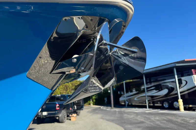  Yacht Photos Pics 2024 Sea Hunt Ultra 305 SE boat propeller, shiny and metallic, with a blue hull background.