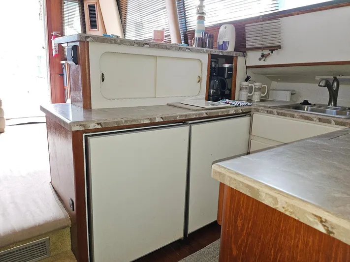 Relentless Yacht Photos Pics 1993 Tiara Yachts 4300 Convertible kitchen with countertops, sink, and storage cabinets.