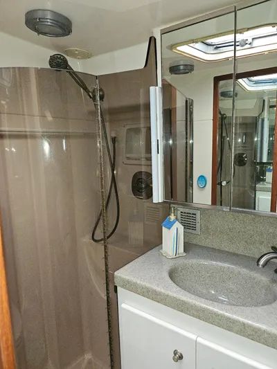 Relentless Yacht Photos Pics 1993 Tiara Yachts 4300 Convertible bathroom with shower, sink, and mirrored cabinet.