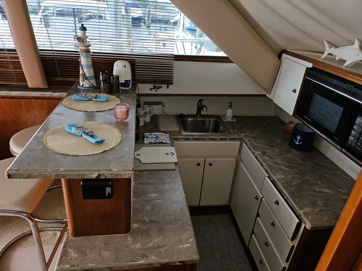 Relentless Yacht Photos Pics 1993 Tiara Yachts 4300 Convertible kitchen with counter, sink, and nautical decor.