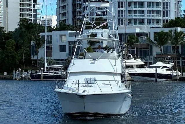 Relentless Yacht Photos Pics 1993 Tiara Yachts 4300 Convertible in marina, surrounded by modern buildings and palm trees.