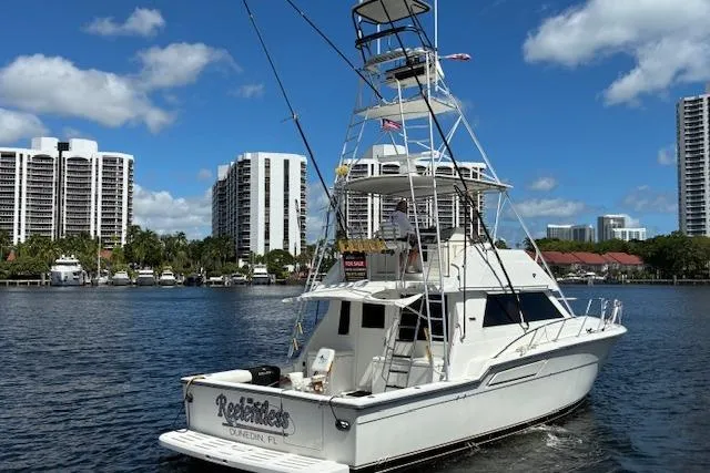 Relentless Yacht Photos Pics 1993 Tiara Yachts 4300 Convertible cruising near waterfront cityscape.