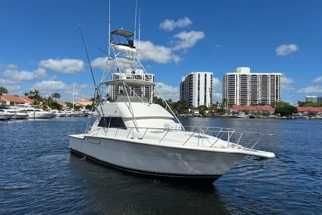 Relentless Yacht Photos Pics 1993 Tiara Yachts 4300 Convertible boat on water, with cityscape background.