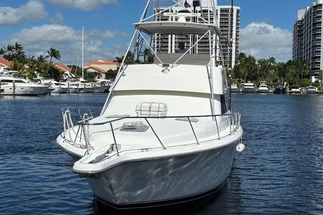 Relentless Yacht Photos Pics 1993 Tiara Yachts 4300 Convertible boat docked in a marina with cityscape background.