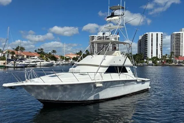 Relentless Yacht Photos Pics 1993 Tiara Yachts 4300 Convertible in marina, clear sky, waterfront buildings.