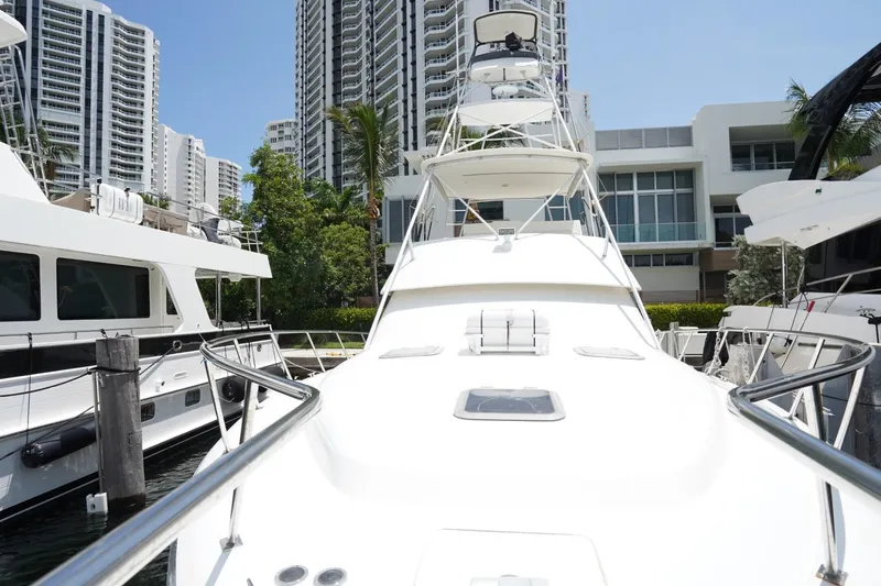 Relentless Yacht Photos Pics 1993 Tiara Yachts 4300 Convertible docked near modern high-rise buildings.