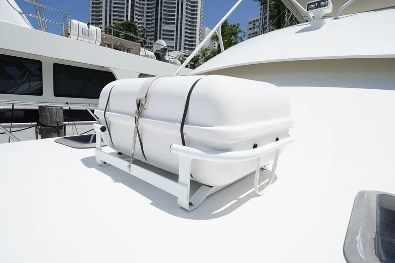 Relentless Yacht Photos Pics 1993 Tiara Yachts 4300 Convertible with life raft on deck, docked near high-rise buildings.