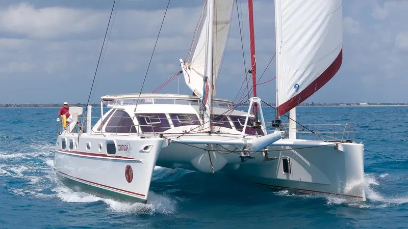 Tortuga Yacht Photos Pics Sailing Catana 582 catamaran from 2001 on open sea, white sails unfurled.