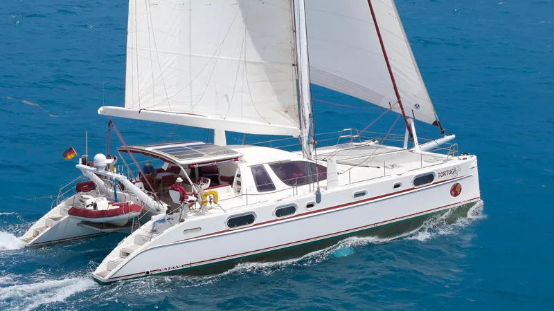 Tortuga Yacht Photos Pics 2001 Catana 582 catamaran sailing on clear blue ocean waters.