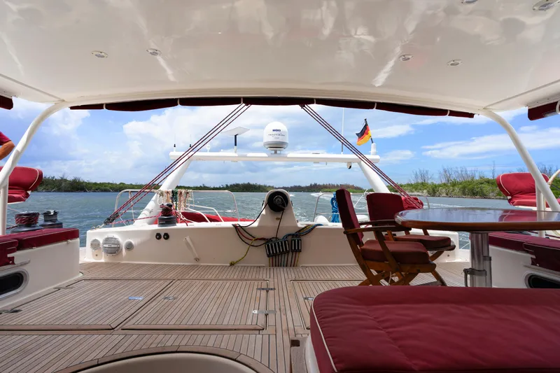 Tortuga Yacht Photos Pics Luxurious Catana 582 yacht deck with red seating, wooden flooring, and scenic water view.