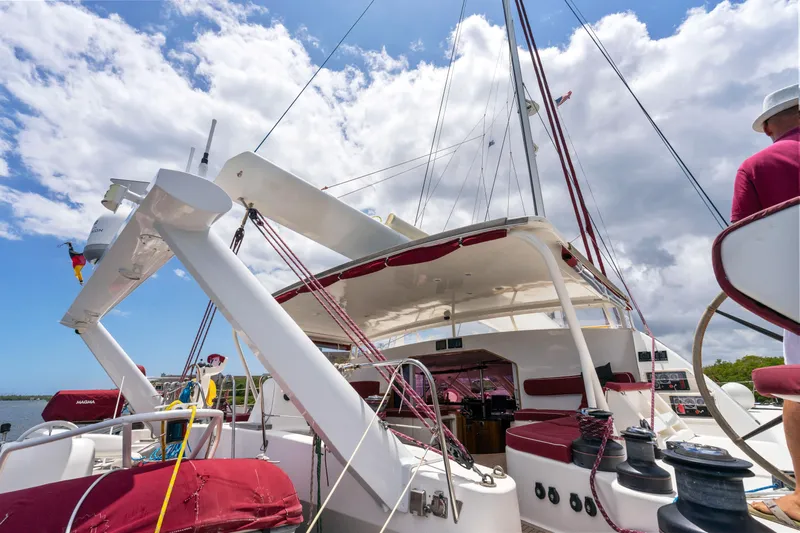 Tortuga Yacht Photos Pics 2001 Catana 582 catamaran with red accents, docked under a partly cloudy sky.