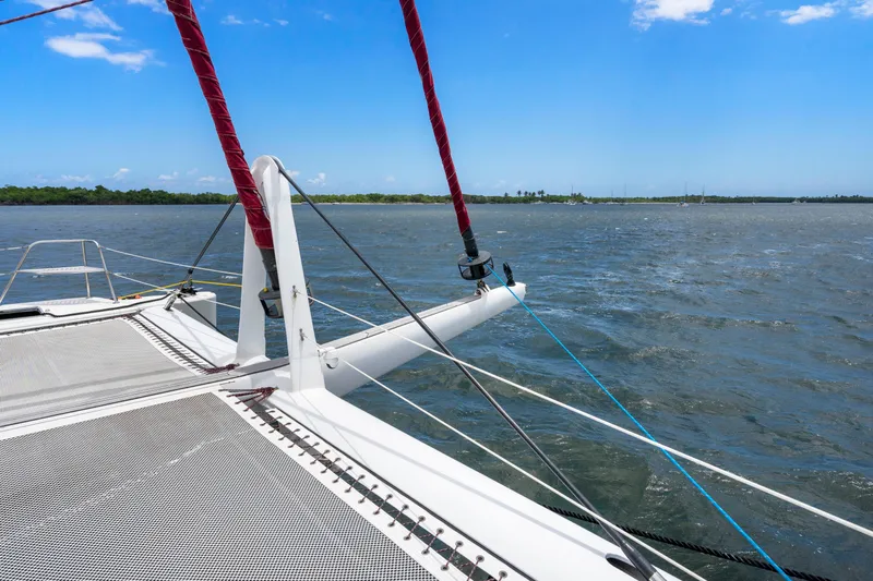 Tortuga Yacht Photos Pics Catana 582 catamaran sailing on open water, 2001 model, clear sky, and distant shoreline.