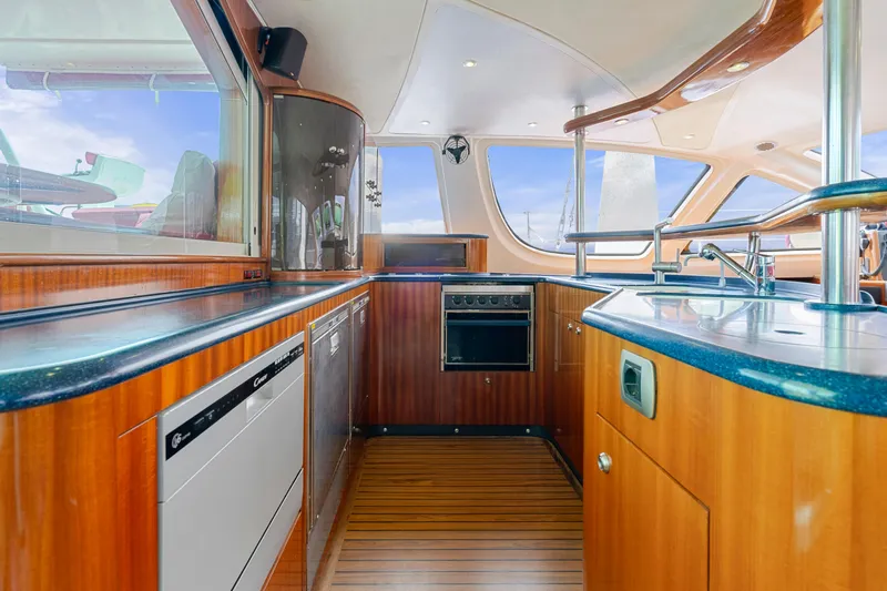Tortuga Yacht Photos Pics Spacious kitchen interior of 2001 Catana 582 yacht with modern appliances and wooden cabinetry.