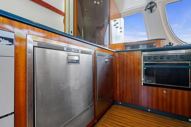 Tortuga Yacht Photos Pics Catana 582 yacht kitchen interior with stainless steel appliances and wooden cabinetry, 2001 model.