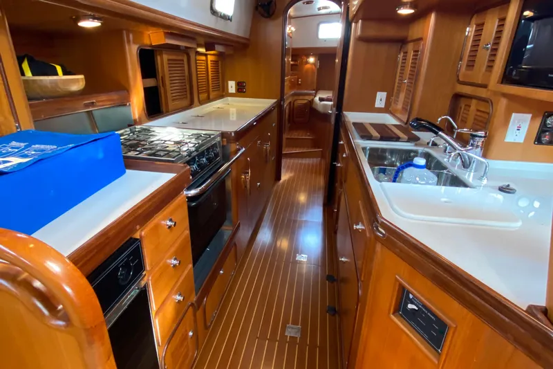 Eos Yacht Photos Pics Luxurious 2006 Passport 470 yacht interior with modern kitchen and wooden cabinetry.