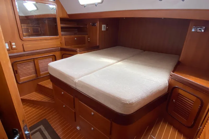 Eos Yacht Photos Pics Luxurious 2006 Passport 470 yacht cabin with wooden interior and comfortable bedding.