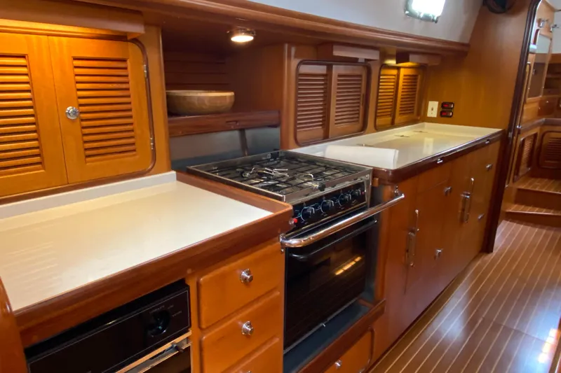 Eos Yacht Photos Pics Luxurious wooden kitchen interior of 2006 Passport 470 yacht with stove and cabinets.