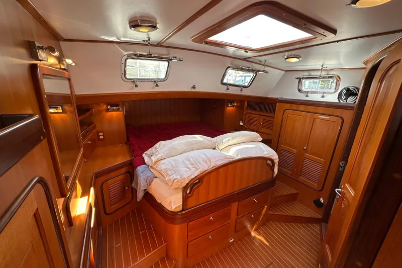 Eos Yacht Photos Pics Luxurious 2006 Passport 470 yacht cabin with wooden interior and cozy bedding.