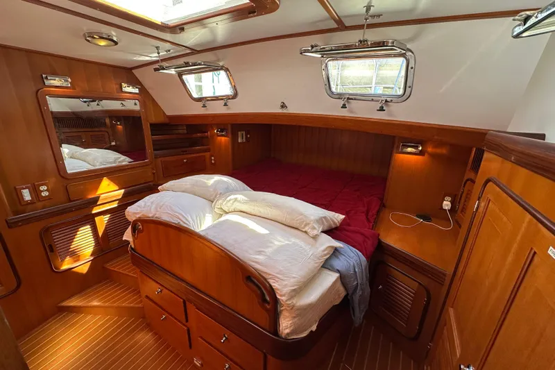 Eos Yacht Photos Pics Luxurious 2006 Passport 470 yacht cabin with wooden interior and cozy bedding.