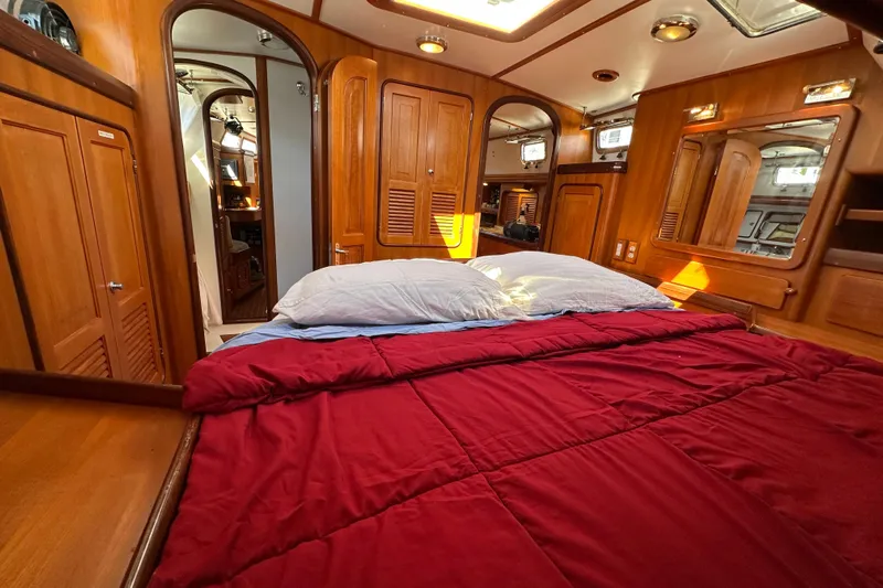 Eos Yacht Photos Pics Luxurious 2006 Passport 470 yacht cabin with red bedding and wooden interior.