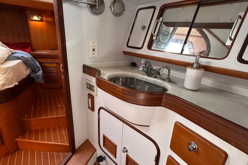 Eos Yacht Photos Pics 2006 Passport 470 yacht interior with wooden cabinetry and compact bathroom sink area.