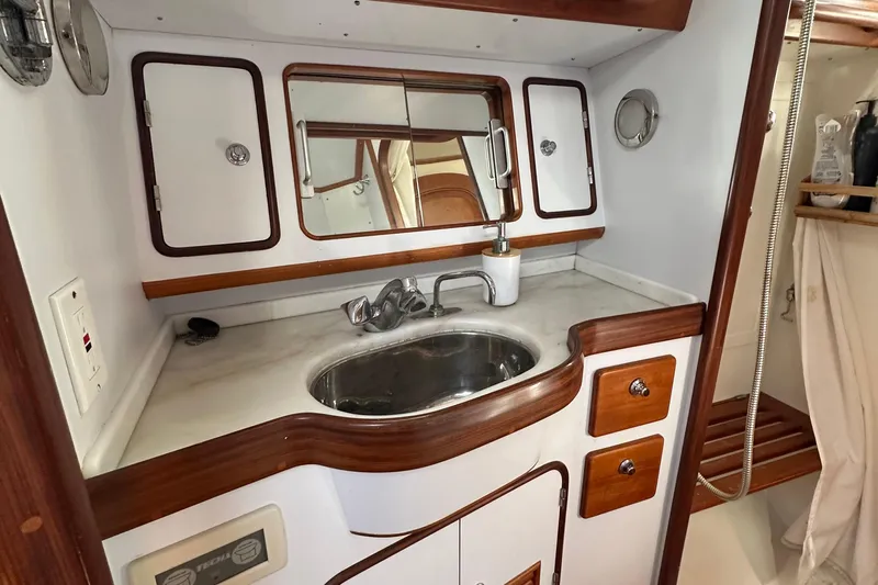 Eos Yacht Photos Pics Compact bathroom in 2006 Passport 470 yacht with sink, mirror, and wooden accents.