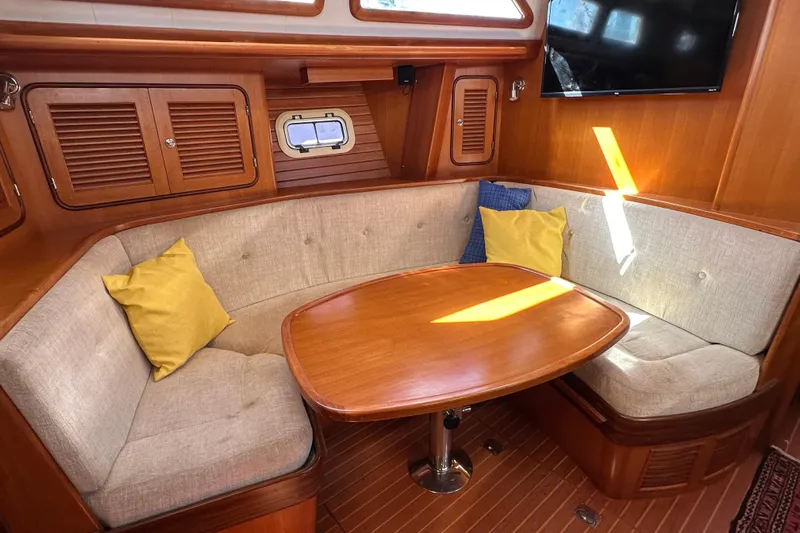 Eos Yacht Photos Pics Cozy interior of 2006 Passport 470 yacht with cushioned seating and wooden table.