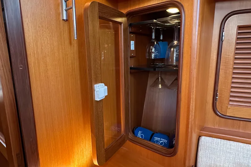 Eos Yacht Photos Pics Wooden cabinet with glassware inside, aboard a 2006 Passport 470 yacht.