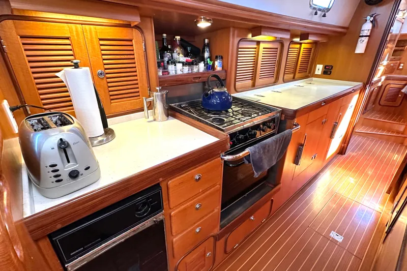 Eos Yacht Photos Pics Luxurious 2006 Passport 470 yacht kitchen with wooden cabinetry, stove, and modern appliances.