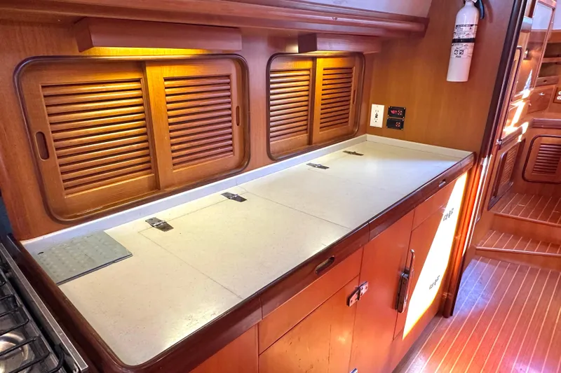 Eos Yacht Photos Pics 2006 Passport 470 yacht interior with wooden cabinets and countertop in galley area.