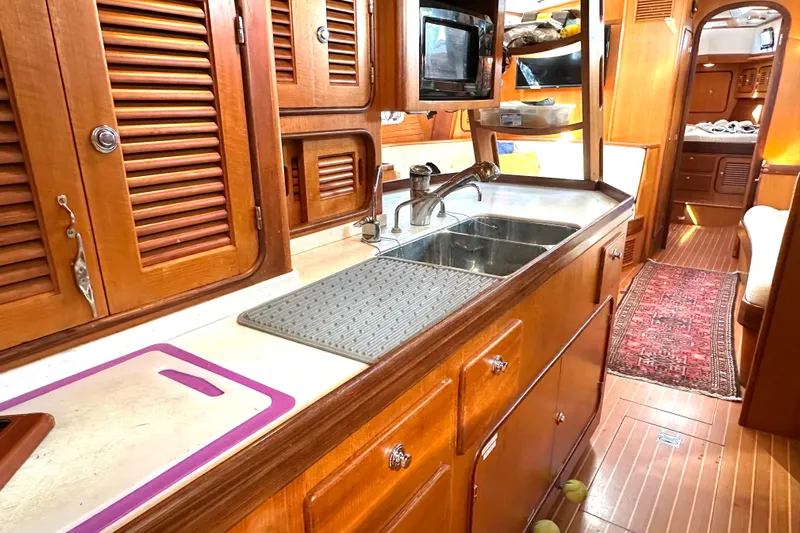 Eos Yacht Photos Pics Luxurious wooden interior of a 2006 Passport 470 yacht kitchen with sink and cabinets.