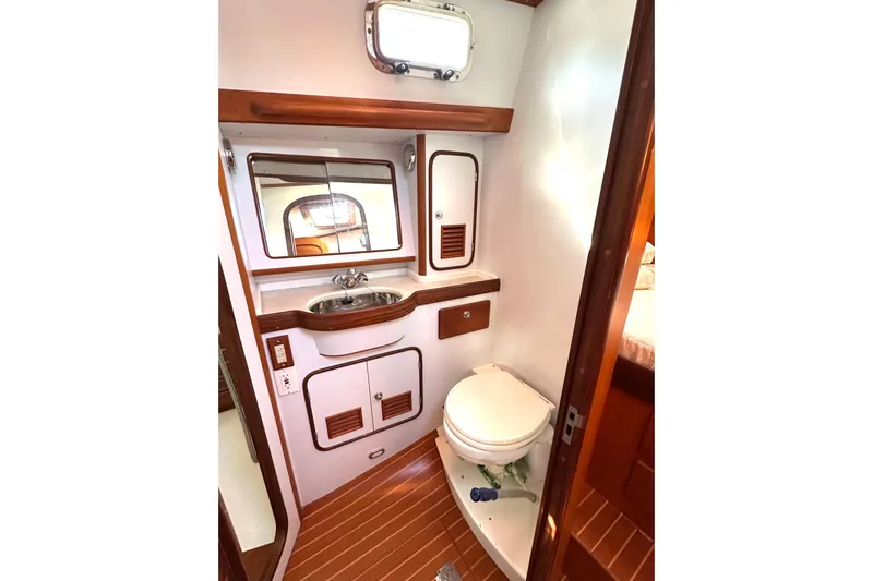 Eos Yacht Photos Pics Luxurious 2006 Passport 470 yacht bathroom with wooden accents and modern fixtures.