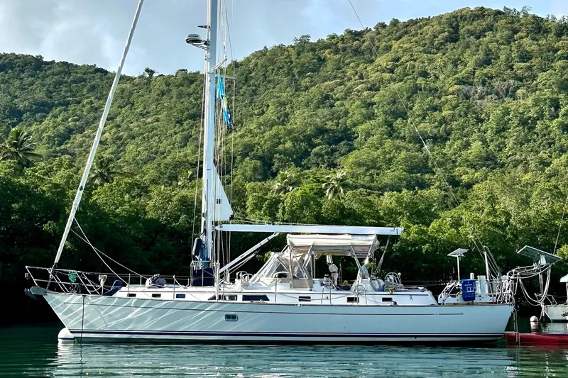 Eos Yacht Photos Pics Sailboat Passport 470, 2006 model, anchored near lush green hillside.
