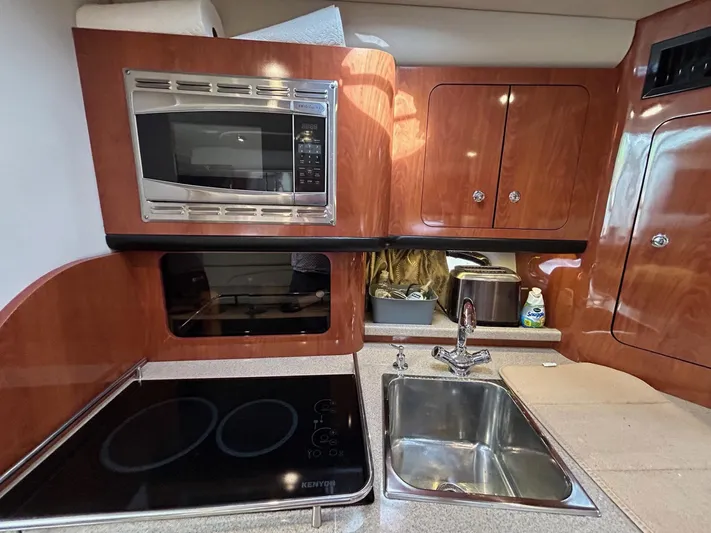  Yacht Photos Pics 2015 Crownline 350 SY yacht kitchen with microwave, stove, and sink.