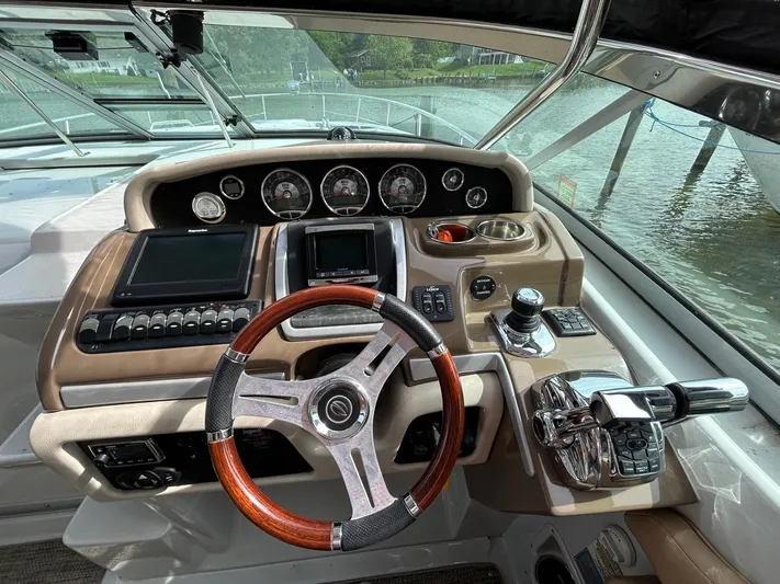 Yacht Photos Pics Helm of 2015 Crownline 350 SY boat with wood-accented steering wheel and modern controls.