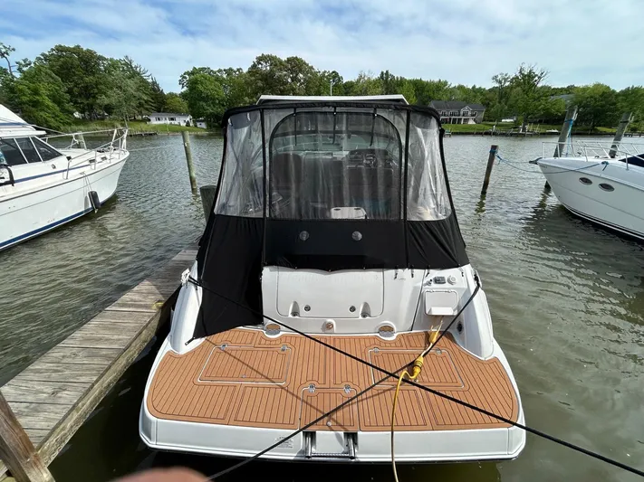  Yacht Photos Pics 2015 Crownline 350 SY boat docked, rear view with black canopy and wooden deck.