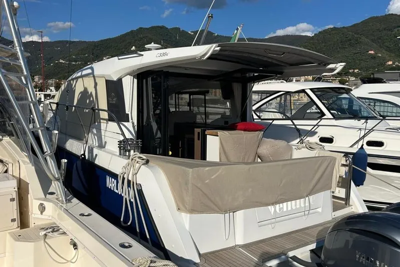  Yacht Photos Pics 2022 Sealine C335V yacht docked at marina with scenic mountain backdrop.